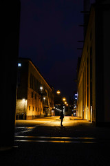 Norrkoping, Sweden A man stands at night in the old and renovated industrial mill section of town.