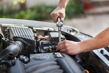 Obraz premium Man master repairs under the hood of the car