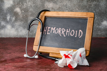Chalkboard with word HEMORRHOID on table