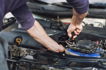 Man master repairs under the hood of the car