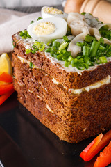 a huge herring sandwich with mayonnaise and quail eggs