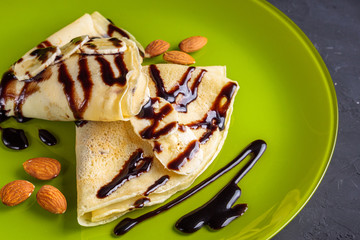 crepes with banana and chocolate spread on a green plate