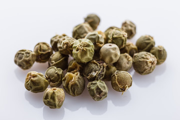 spicy green peppers on white acrylic background