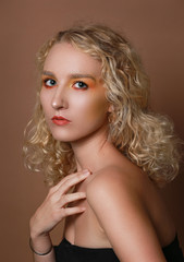 Close up beauty portrait of blonde girl on brown background