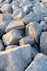 Close up. rock stone breakwater at the pier on the beach.