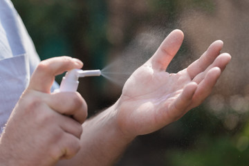 Man wipes her hands with alcohol-based hand-washing spray. Sars-CoV-2 and Covid-19 infection