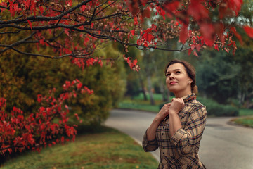 a beautiful Turgenev Russian girl walks through an autumn park and read a book by Russian writer Dostoevsky's Crime and Punishment