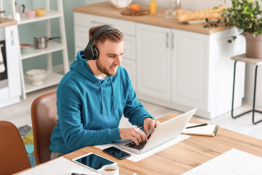Young man with laptop working at home
