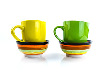 Porcelain cups of different colors stand on a white background.