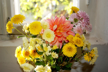 Bouquet of yellow and orange flowers on the window