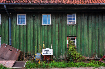 Abandones tagline Votes for Women, and wheelbarrow for worker in Christiania Freetown with wooden...