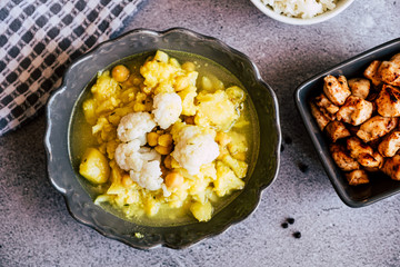 Curry de légumes avec des patates chou-fleur et pois chiche avec des dés de poulet caramélisés