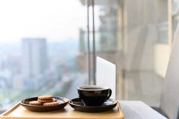 laptop with coffee and cookies nearby on the balcony concept of work from home