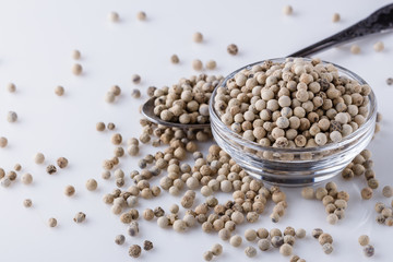 white peppercorns in glass bowl with spoon
