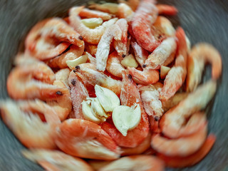 Giant orange shrimps fried in oil in a frying pan on a gas stove