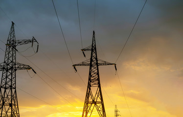High-voltage power lines on sunset background