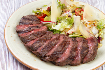 salad and sliced steak in a plate.