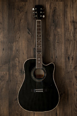 Obraz na płótnie Canvas black acoustic guitar on wooden background