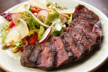 salad and sliced steak in a plate.