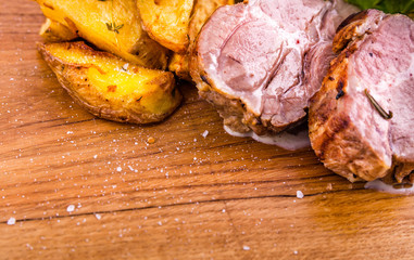 Fried pork neck with potato..gratin and creamy mushroom sauce on a wooden board