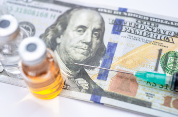 A dollar bill and stethoscope with syringe is inserted into the bill. The concept is the fall of the economy. Inflation, covid-19 pandemic, Health care cost concept