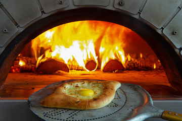 A traditional cheese pie is taken out of the oven.