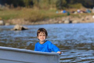 Child boating on the lake, on a beautiful autumn day
