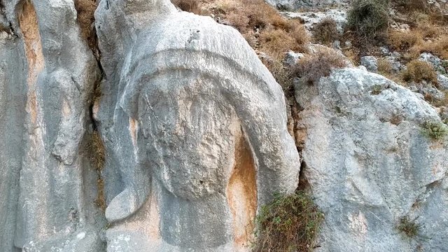 close flight around the huge statue of charon engraved on a rock at st. pierre church location, antakya, turkey