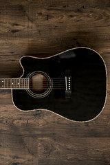 black acoustic guitar on wooden background
