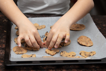 Close-up child`s hands preparing cookies