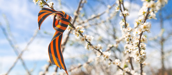 May 9, Victory Day holiday. Holiday card with order, St. George ribbon, flowers and military cap. May 9 background, copy space and translation with Victory Day.