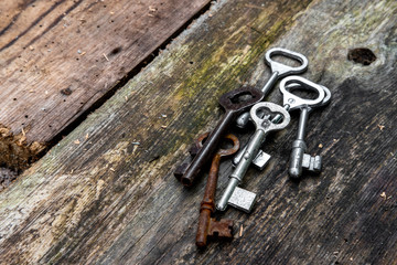Old keys of different sizes on rustic weathered wood planks