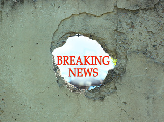 Breaking News sign in concrete fence hole. Infodemic in COVID-19 pandemic. True coronavirus world...