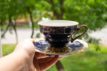 antique cup of tea in hand