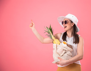 Portrait of a young stylish woman with an eco-fruit bag .