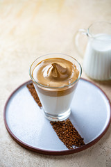 Dalgona Coffee with almond milk. Trendy corean recipe of whipped coffee, reverse latte or homemade dalgona coffee, copy space Dalgona Coffee, a combination of hot and cold beverage drink