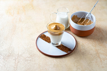 Dalgona Coffee with almond milk. Trendy corean recipe of whipped coffee, reverse latte or homemade dalgona coffee, copy space Dalgona Coffee, a combination of hot and cold beverage drink