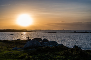Un couple contemple un coucher de soleil 