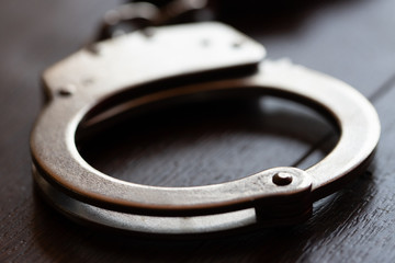 steel metal Handcuffs on brown background