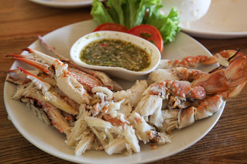 Steamed Crab Oars With seafood sauce on white dish on wood table