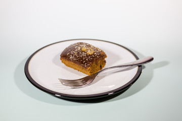 A vegan sticky toffee pudding that has been sliced and put on a plate ready to eat