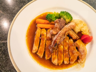 Grilled chicken with soy sauce on white plate