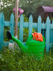 Watering can, protective gloves and metal spade.