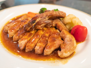 Grilled chicken with soy sauce on white plate