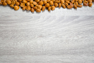 The brown seeds of the Indian rose chestnut stacked on a gray wooden table.