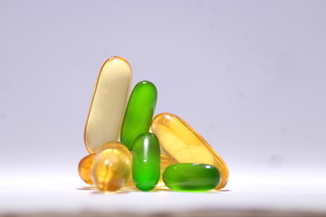 omega 3 fish oil capsule with vitamin E green capsule and vitamin B on white background 