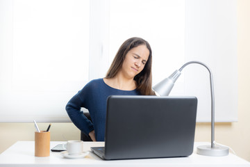 Teen student suffers back pain with computer at home