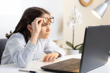 Girl with eyesight problems trying to read with her glasses