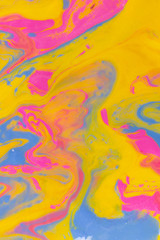 Fototapeta na wymiar Abstract background of mixed shades of nail polish with a marble pattern. Liquid colorful paint background creative watercolor neon pink, blue, yellow