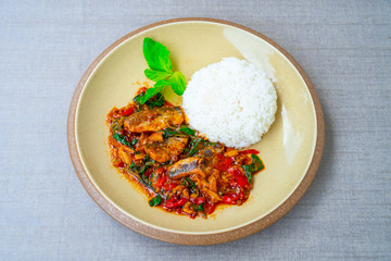 Stir-fried spicy canned fish with basil leaves served with Thai jasmine rice. Sardines in tomato sauce fried with spicy basil. Thai style food. Popular street food in Thai.
